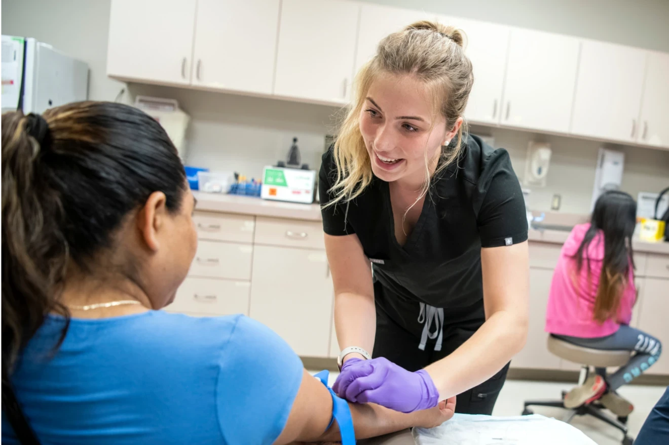 Student working in the free clinic assisting a patient