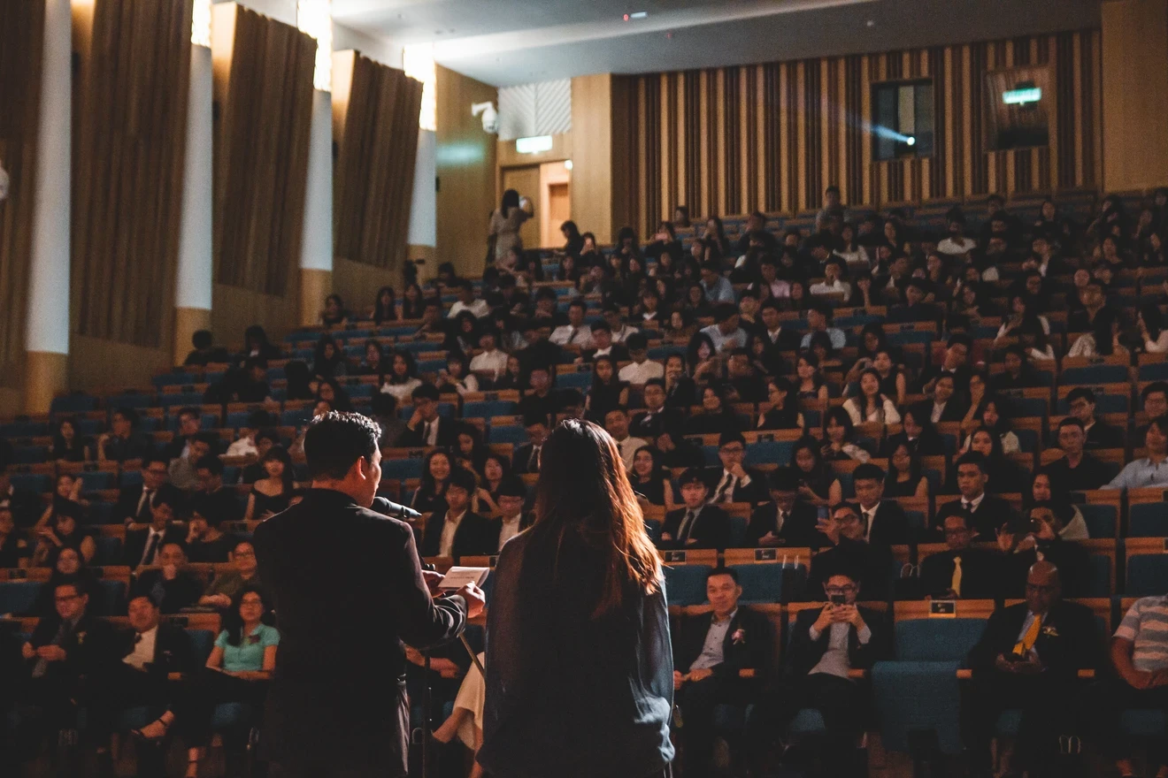 Two speakers in front of a crowd at a confefrence