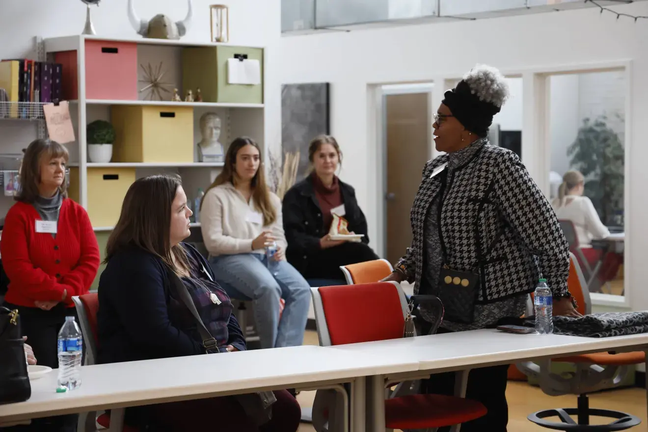 A woman standing and talking to students