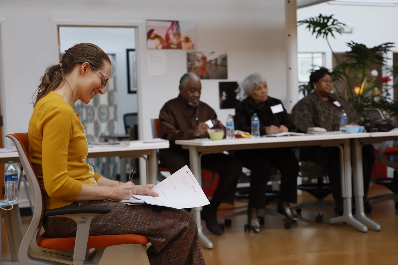 Student taking notes and three community health mentors in the background