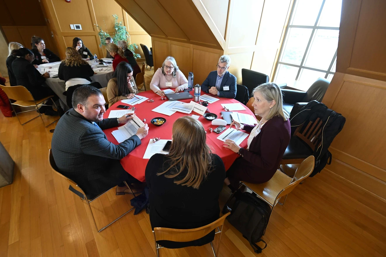 A team of interprofessional colleagues discussing around a round table