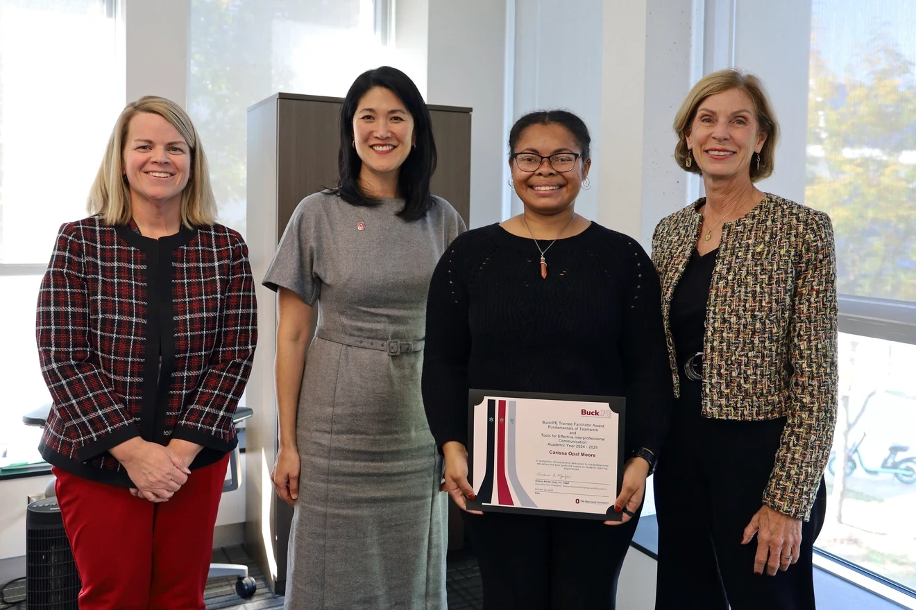 Three people presenting award to recipient